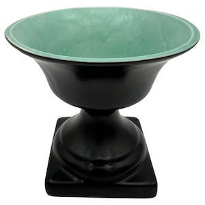 以下が含まれることがあります： 正方形のベースと丸みを帯びた上部を備えた黒いセラミック製の台座ボウル。ボウルの内側は明るいティール色で、黒い外観とは対照的です。ボウルはクラシックでエレガントなデザインです。