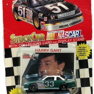 May include: A 1994 Racing Champions NASCAR die-cast car featuring a green and white #33 car and a black and white #51 car. The packaging includes the text "STOCK CAR" and "NASCAR" with a picture of Harry Gant.