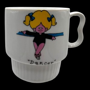 Puede incluir: Una taza de cerámica blanca con un asa negra y el texto "But First, Coffee" en negro, con una fuente de estilo manuscrito. La taza está sobre una superficie blanca.