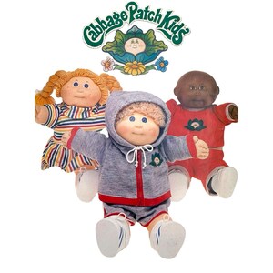May include: Three Cabbage Patch Kids dolls featuring the brand logo at the top. One doll has blonde braided hair and a striped dress, one wears a grey hooded zip-up tracksuit, and one has dark skin and wears a red outfit with a green emblem.