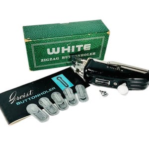 Pode incluir: Um kit de acessórios para máquina de costura vintage, incluindo um caseador em zigue-zague preto e prateado, uma caixa verde com o texto "WHITE ZIGZAG BUTTONHOLER" e um livreto preto com o texto "Greist BUTTONHOLDER". Inclui também guias de casa de botão de plástico transparente.