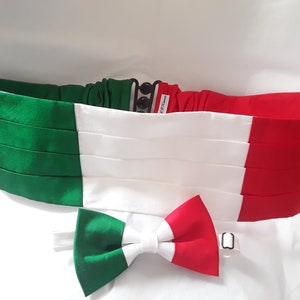 May include: A green, white and red bow tie and cummerbund set. The bow tie and cummerbund are made of satin and have a pleated design. The set is ideal for a formal occasion.