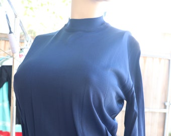 May include: A navy blue long-sleeved shirt with a mock neck.