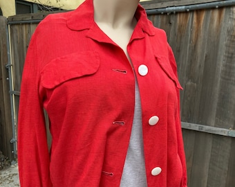 May include: A red button-up jacket with long sleeves and white buttons. The jacket has two flap pockets on the front.