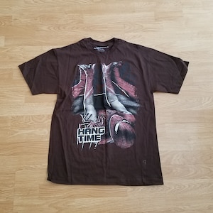 May include: Brown t-shirt with a graphic print of Spiderman hanging upside down. The text "Hang Time" is printed below the image.