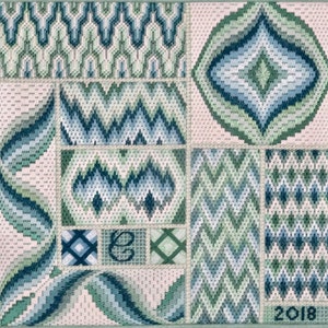 May include: A cross-stitch sampler with a variety of geometric patterns in shades of green and blue. The sampler includes the letter "E" and the year "2018".