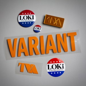 May include: Three red, white, and blue circular buttons with the text "Loki for President" and a smaller blue button with the text "Loki". A gold metal sticker with the text "1111" and a clear sticker with the text "VARIANT" in orange letters.