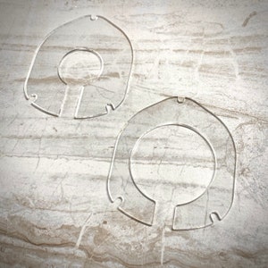 May include: Two clear plastic rings with a smaller hole in the center of each ring.