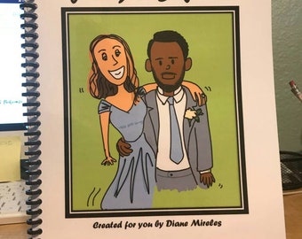 May include: A white book with a black spiral binding. The cover features a cartoon illustration of a couple, a woman with long brown hair and a man with short black hair, in a light blue and green frame. The text "The Story of Jenny & Bikonzo" is printed in black at the top of the cover. The text "Created for you by Diane Mireles" is printed in black at the bottom of the cover.