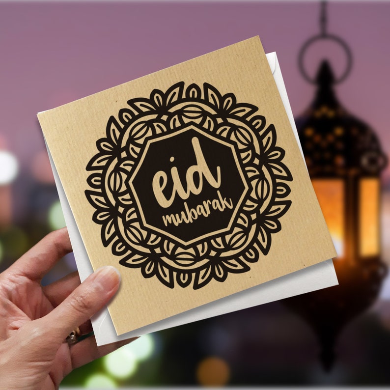May include: A brown card with a black and white mandala design. The mandala has a black hexagon in the center with the text "eid mubarak" in white.