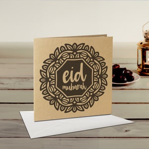 May include: A brown card with a black and white mandala design and the text "eid mubarak" in a black octagon.