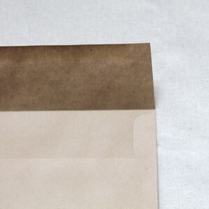 May include: A brown paper envelope with a white flap. The envelope is closed and ready to be mailed.