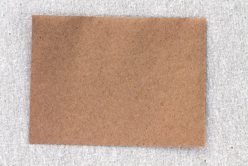 May include: A brown paper card with a rough texture. The card is blank and ready for writing or drawing.