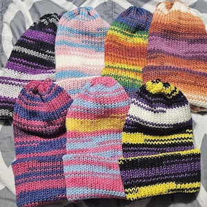 May include: Seven striped knit hats in various colors, including purple, pink, blue, yellow, orange, and black.