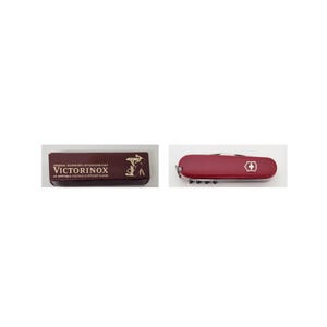 Puede incluir: Una navaja suiza roja con un emblema de cruz blanca y una funda de cuero marrón. La funda tiene letras doradas que dicen "Victorinox" y "Original Schweizer Offiziersmesser". La navaja tiene múltiples herramientas.