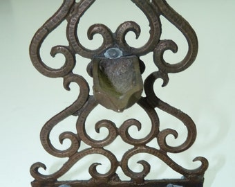 Può includere: Un candelabro a sette bracci in bronzo con un design decorativo a volute. Il candelabro ha nove portacandele e una lampada ad olio centrale.