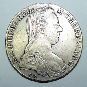 May include: Silver coin featuring a bust of a woman with the inscription "R.IMP-HU-BO-REG. M-THERESIAD G" and "S-F" on the bottom.
