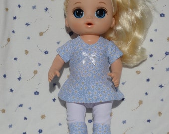 Cute handmade dress in a blue with white daisy flower print and white leggings with a circle patch on the back, fits 13 inch baby dolls