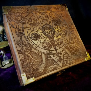 May include: A wooden box with a brass latch and hinges. The lid is engraved with a circular design featuring a star, a man's face, and various symbols. The text "Rectficando" is visible on the lid.