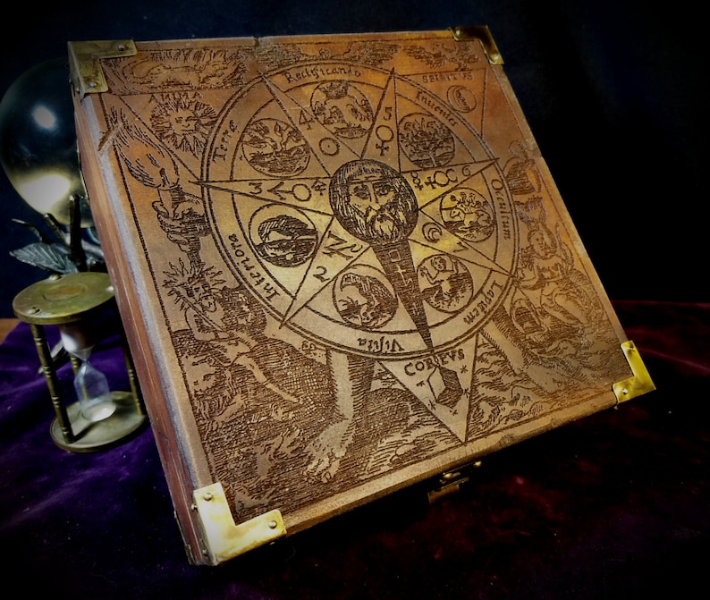 May include: A wooden box with a brass latch and hinges. The lid is engraved with a circular design featuring a star, a man's face, and various symbols. The text "Rectficando" is visible on the lid.