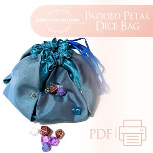 May include: Teal padded dice bag with a drawstring closure and blue satin ribbon ties. The bag is filled with colorful dice. The text "PADDED PETAL DICE BAG" is printed on a pink background.