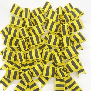 May include: A set of 12 yellow and black striped bows. The bows are made of ribbon and have a simple, classic design. They are perfect for adding a touch of colour and cheer to any occasion.