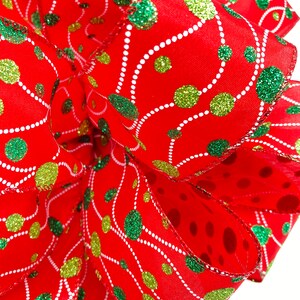 May include: Red ribbon with green and gold glitter polka dots and white swirl design.
