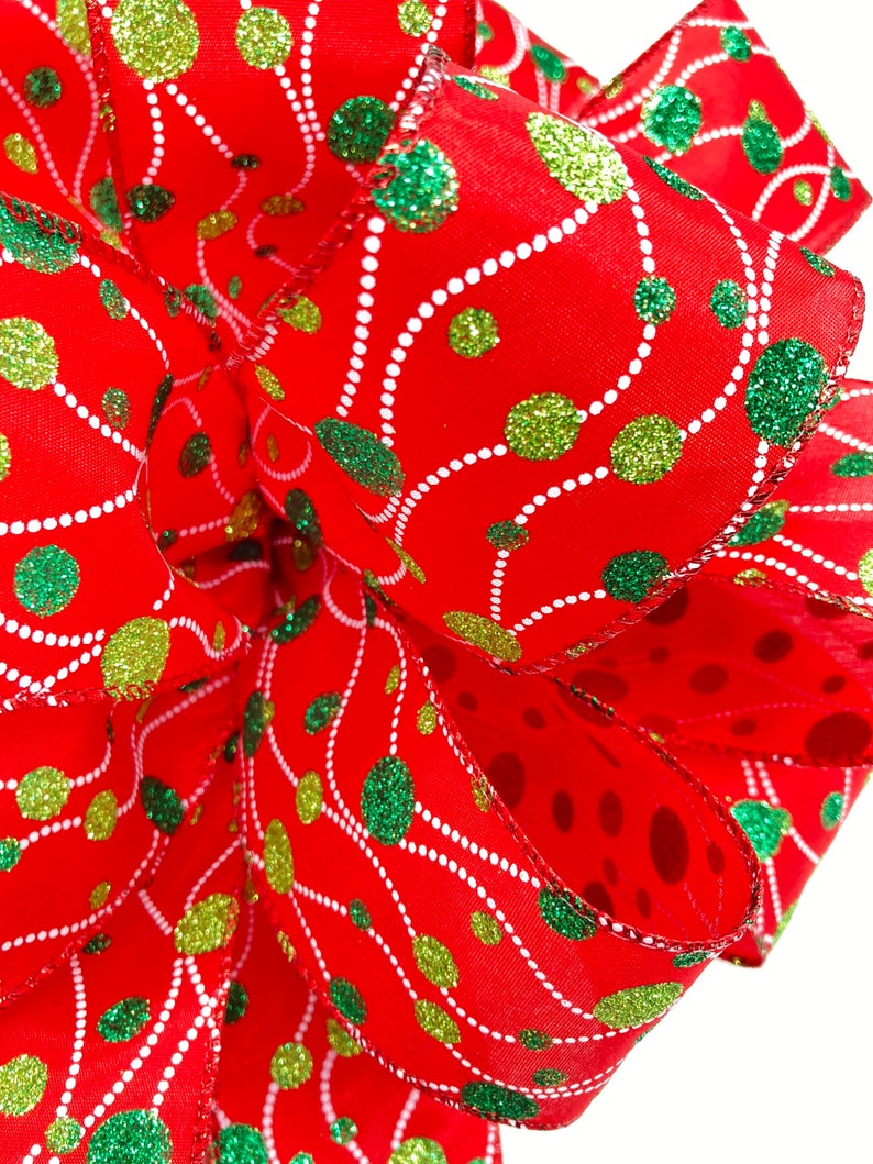May include: Red ribbon with green and gold glitter polka dots and white swirl design.