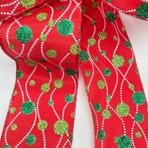 May include: Red ribbon with a white and green polka dot pattern. The dots have a glitter finish.
