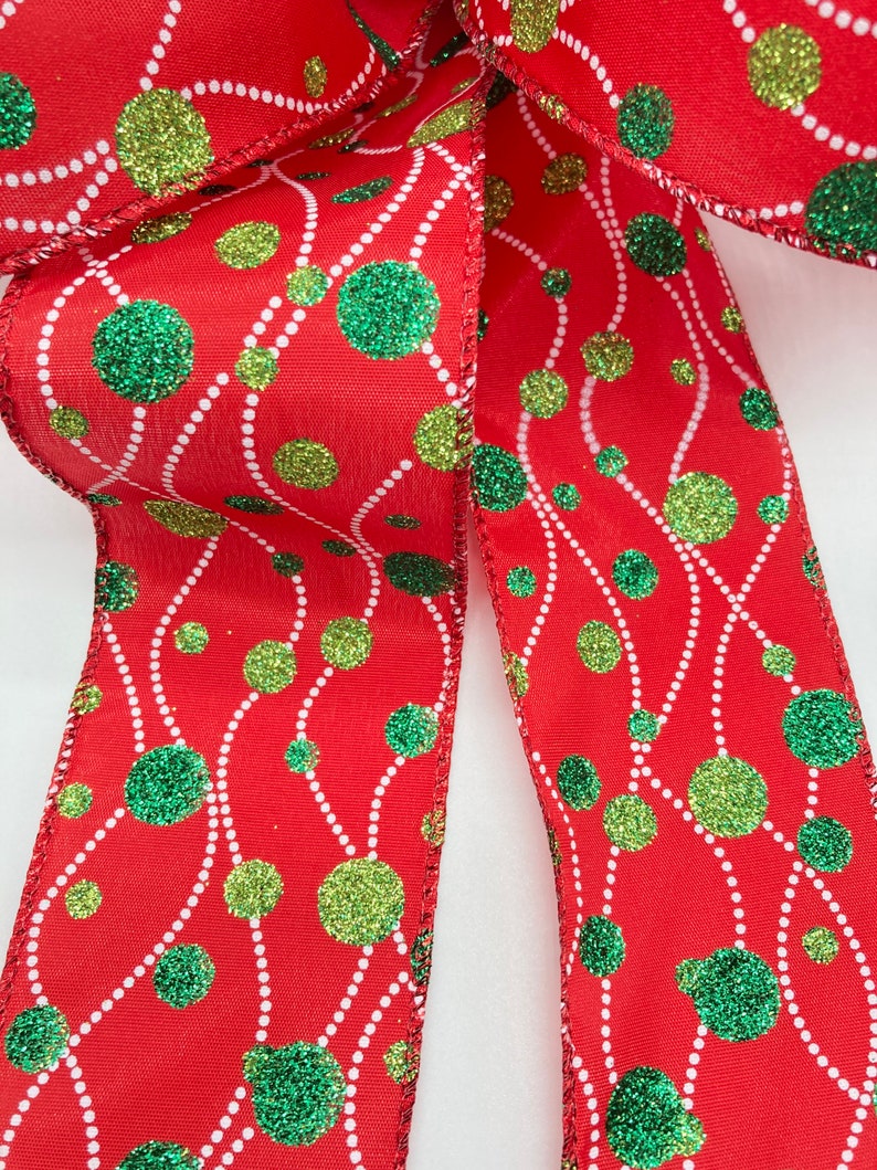 May include: Red ribbon with a white and green polka dot pattern. The dots have a glitter finish.