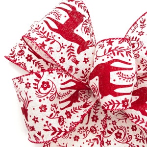 May include: Red and white ribbon with a repeating pattern of stylized reindeer and floral designs. The ribbon has a white background with red reindeer and floral designs.