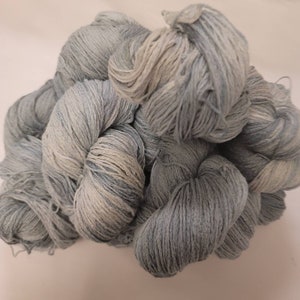 May include: A pile of soft, light blue and white yarn. The yarn is made of cotton and is perfect for knitting or crocheting.