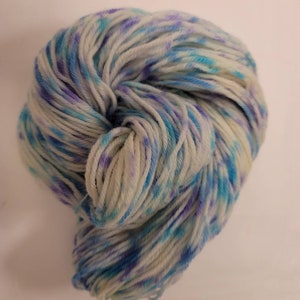 May include: A skein of yarn in a white base with blue and purple speckles.