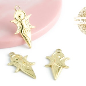 Peut inclure: Trois breloques en métal doré en forme de silhouette féminine stylisée avec une lune croissante de chaque côté. Les breloques sont sur une surface blanche.