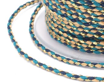 May include: A close-up of a braided cord with teal, navy blue, and gold threads. The cord is twisted and has a metallic sheen.