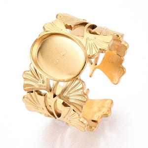 Può includere: Bracciale a polsino regolabile color oro con incastonatura centrale rotonda. Il bracciale è adornato da intricati disegni di foglie di ginkgo, creando un'estetica ispirata alla natura. Il design aperto consente la regolazione, adatto a varie dimensioni del polso.