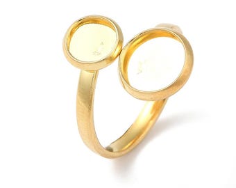 Puede incluir: Anillo de oro con dos engastes redondos vacíos. El anillo es de metal y tiene un acabado liso.