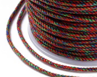 Könnte beinhalten: Nahaufnahme einer Spule mit buntem geflochtenem Kordel. Die Kordel ist eine Mischung aus roten, grünen und blauen Fäden, die eng miteinander verwoben sind. Die Kordel ist um eine weiße Kunststoffspule gewickelt, wobei etwas Kordel abgewickelt ist.