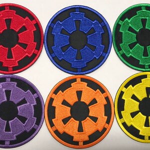 Op de afbeelding: Zes geborduurde patches met het keizerlijke symbool uit Star Wars. De patches zijn in verschillende kleuren: rood, blauw, groen, paars, oranje en geel.