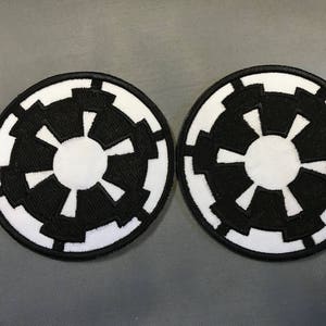 May include: Two black and white embroidered patches with the Star Wars Imperial symbol.