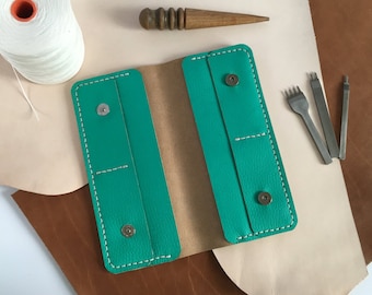 May include: A teal leather wallet with white stitching and silver snaps. The wallet is open and the inside is brown leather.