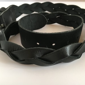 May include: A black leather belt with a braided design and a silver buckle.