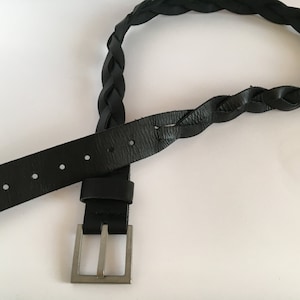 May include: A black leather belt with a braided design and a silver buckle.