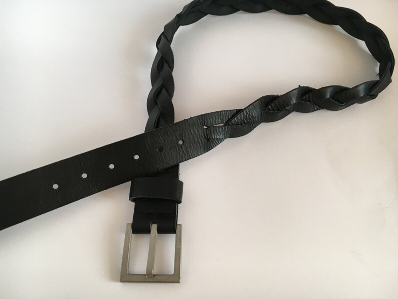 May include: A black leather belt with a braided design and a silver buckle.