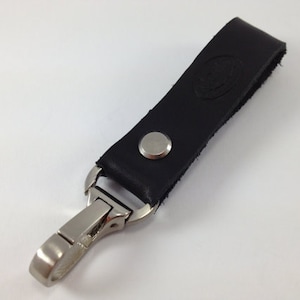 May include: Black leather key chain with a silver metal clip and a silver button.