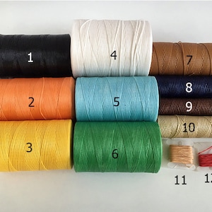 May include: Twelve spools of waxed thread in various colors, including black, white, orange, yellow, blue, green, brown, and beige. The spools are numbered 1 through 12.