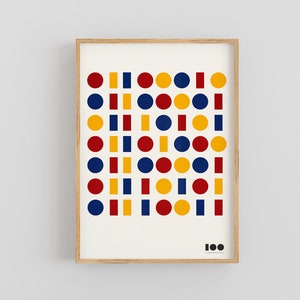 May include: A framed print with a white background and a pattern of red, yellow, and blue circles and squares. The number "100" is printed in black at the bottom of the print.