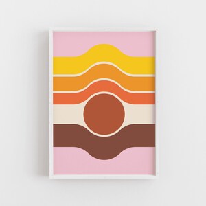 May include: A framed print with a retro abstract design featuring wavy lines in shades of pink, yellow, orange, brown, and cream. A large brown circle is centered in the middle of the print.