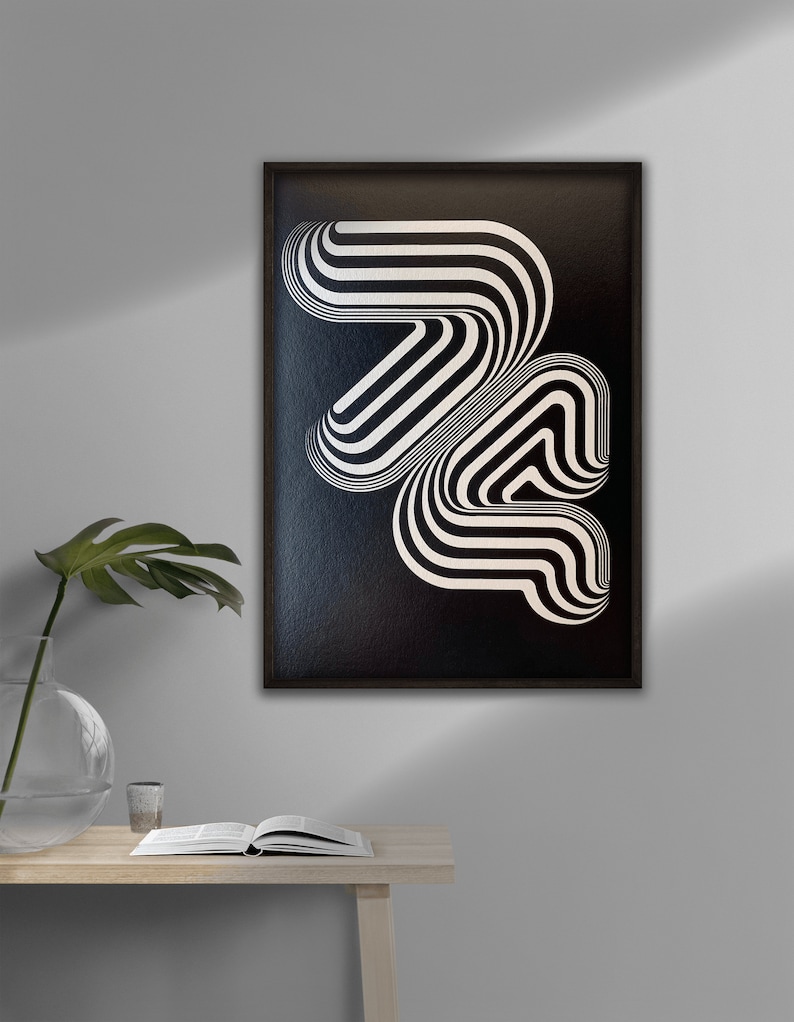 May include: Black and white abstract geometric art print in a black frame. The print features a series of curved lines that create a sense of movement and depth.