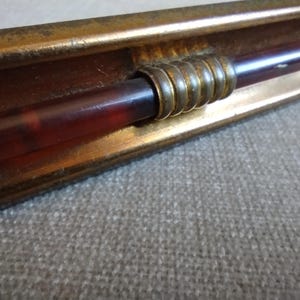 Mid century tarnished metal cabinet or drawer pull with amber bakelite rod